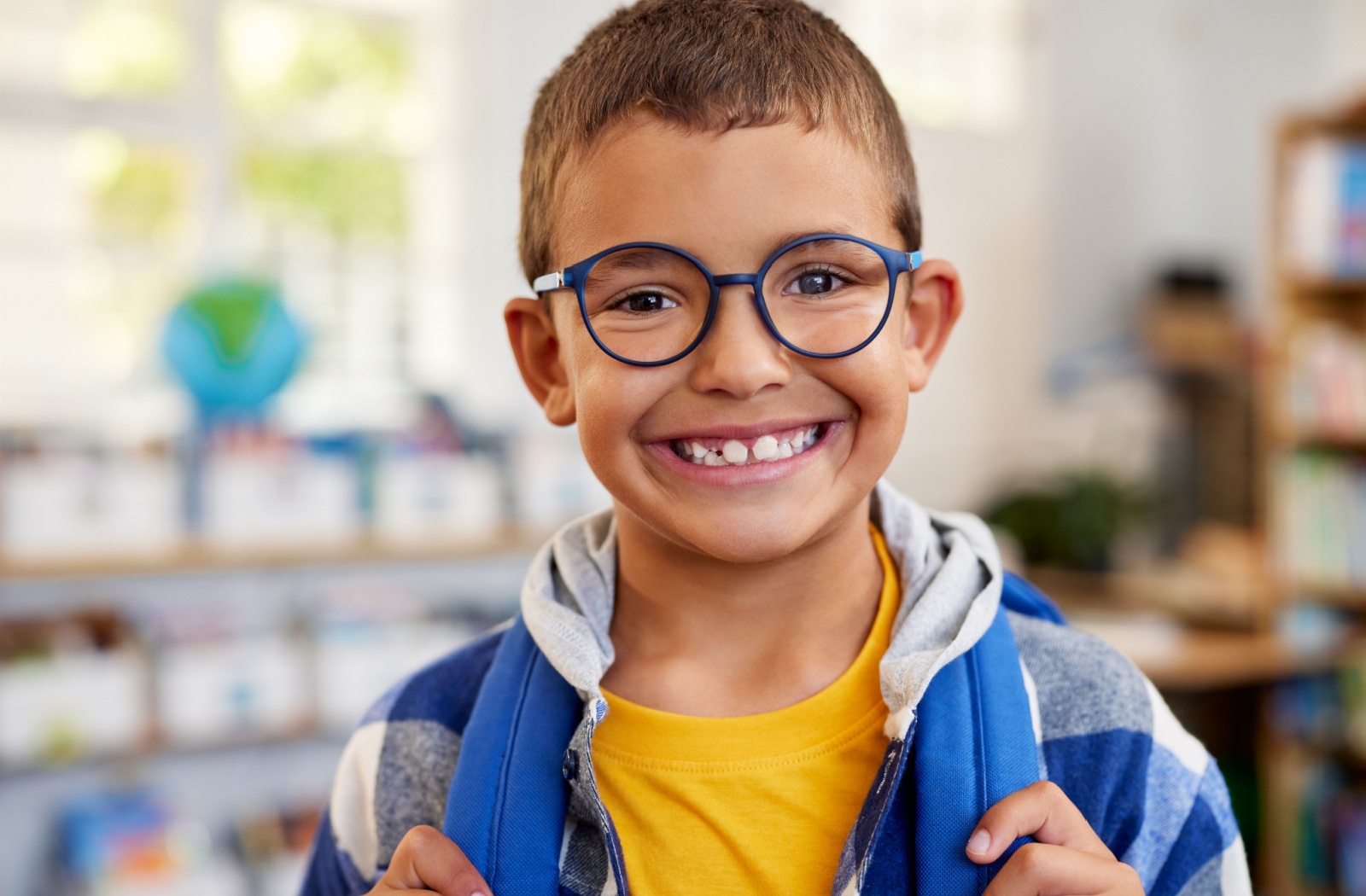 A child smiling while wearing myopia control glasses