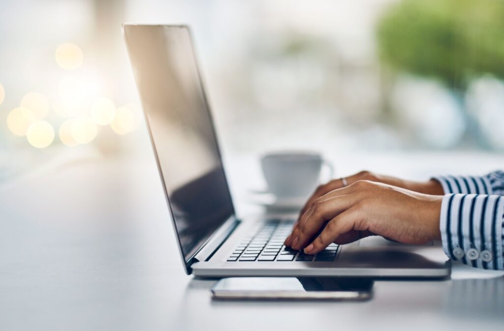 A person typing on their laptop